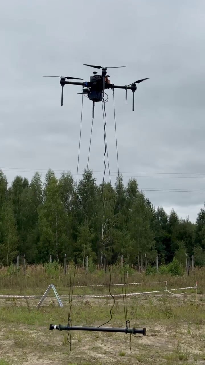 Real field image of UAV carrying a suspended geophysical sensor